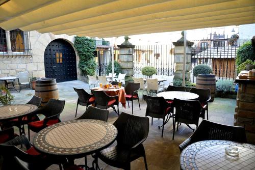 un patio al aire libre con mesas, sillas, mesas y sillas en Hotel Palacete, en Hondarribia