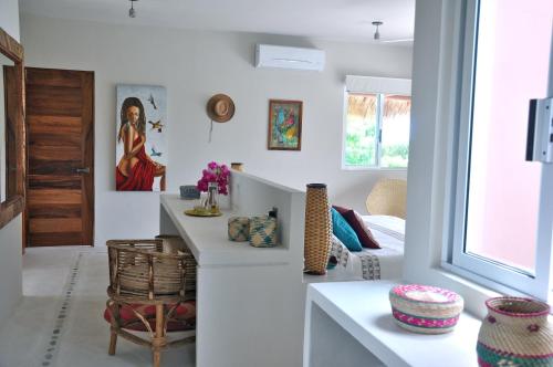 a white living room with a table and a couch at Casa Cometa in San Agustinillo