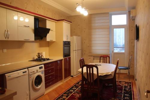 a kitchen with a table and a dining room at Apartment at Jafar Khandan 200 in Baku