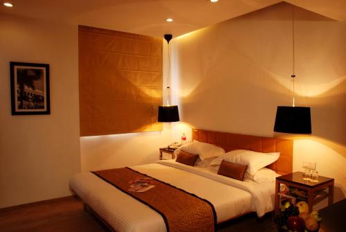 a bedroom with a large bed and two lamps at Hotel Palace Heights in New Delhi