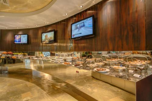 a buffet line with plates of food and a flat screen tv at Hotel Premier & Suites - Premier Resort in Milano Marittima