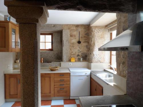 a kitchen with a white refrigerator and a sink at Casa Barqueiro in Outes