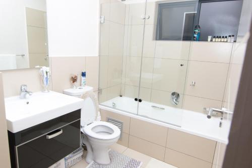 une salle de bain avec toilettes, lavabo et baignoire dans l'établissement Luxury 2 Bedroom Lifestyle Apartment in Golf Estate, à Roodepoort
