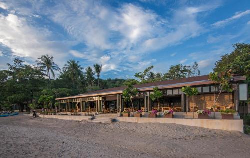 ein Gebäude an einem Strand mit Bäumen im Hintergrund in der Unterkunft Anda Lanta Resort in Ko Lanta