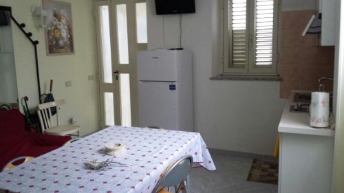 a kitchen with a table and a white refrigerator at Villa Carolina in Fara San Martino
