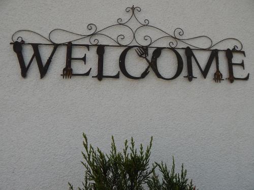 a sign that reads welcome hanging on a wall at TiWu - Ferienwohnungen in Steinhude