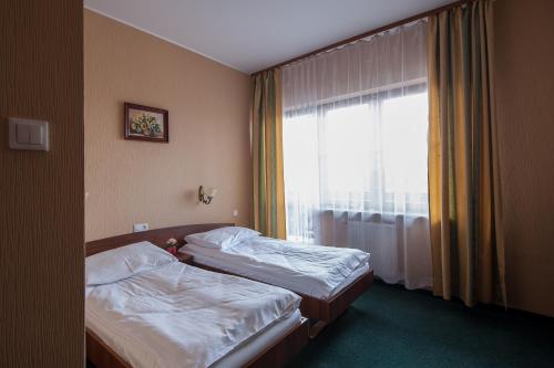 une chambre d'hôtel avec deux lits et une fenêtre dans l'établissement Hotel Hetmański, à Rawa Mazowiecka