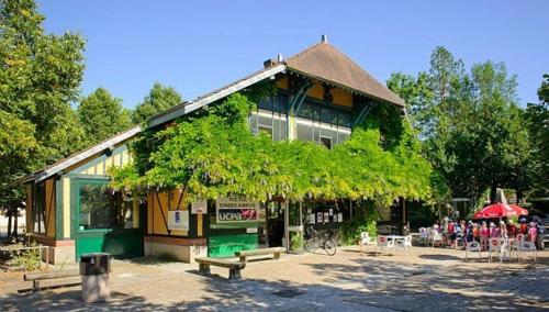 um edifício com bancos e mesas à sua frente em Roulottes de Bois le roi em Bois-le-Roi