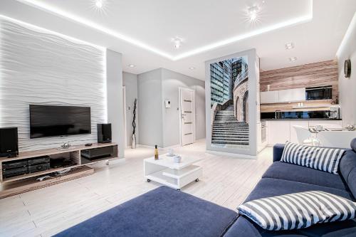 ポズナンにあるCapital Apartments - Towarowaの青いソファとテレビのあるリビングルーム