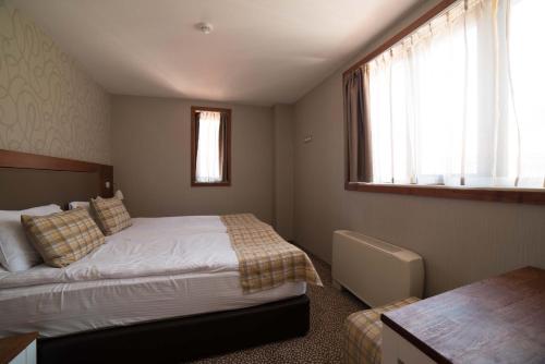 a bedroom with a bed and a window at Ruskovets Thermal SPA & Ski Resort in Bansko