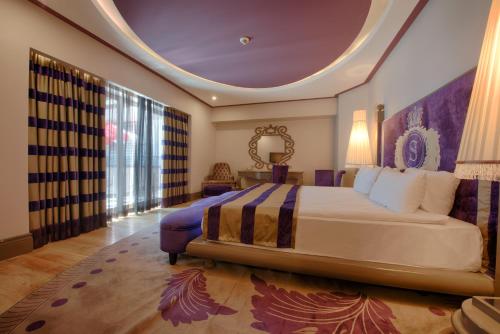 a bedroom with a large bed and a large window at Selectum Luxury Resort Belek in Belek
