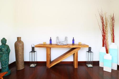 a wooden table with vases and other items on it at Villa Nambung in Selong Belanak