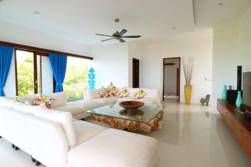 a living room with white couches and a coffee table at Villa Nambung in Selong Belanak