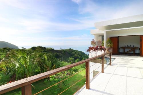 a balcony of a house with a view of the ocean at Villa Nambung in Selong Belanak