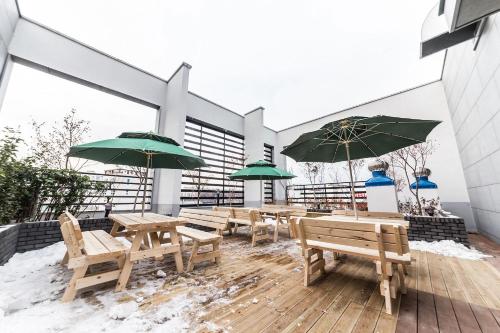 eine Gruppe von Bänken und Sonnenschirmen auf einem Deck in der Unterkunft Jongno Hotel Lumia in Seoul