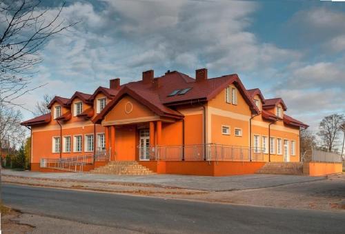 a large orange house on the side of a street at Hotel Fregata in Pęczniew