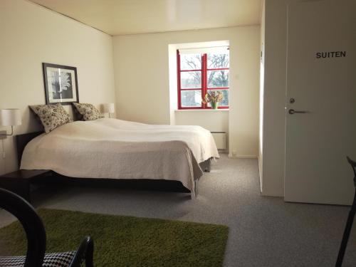een witte slaapkamer met een bed en een raam bij Ølsted Kro & Hotel in Ølsted