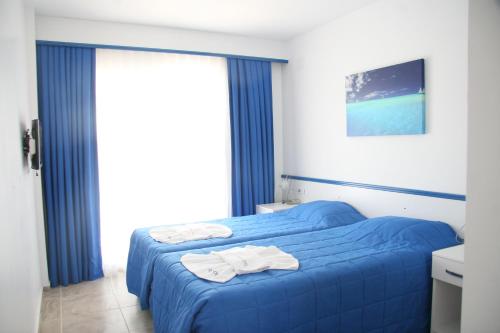 a bedroom with a blue bed with towels on it at Rota Hotel in Dalyan