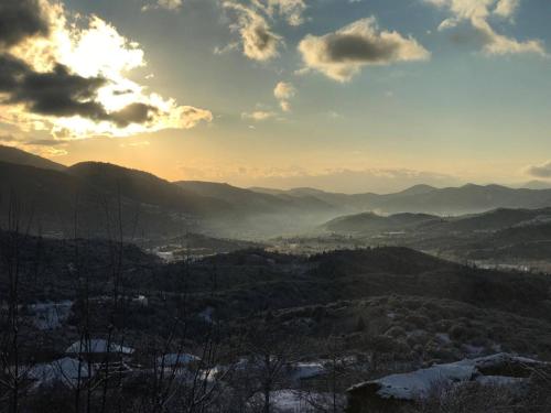 a view of a mountain valley with the sun setting at Hotel Papanikola in Piána