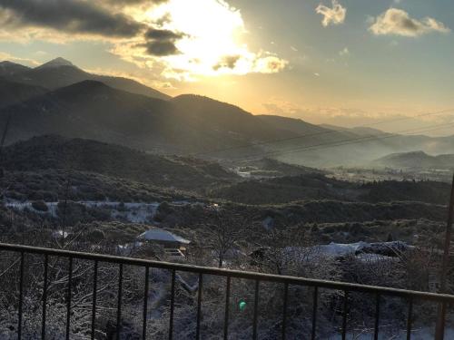 a view of a mountain valley with the sun setting at Hotel Papanikola in Piána