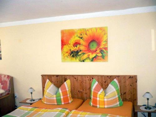 ein Schlafzimmer mit einem Bett mit einem Gemälde einer Sonnenblume in der Unterkunft Serene Apartment with Private Terrace in Wismar in Wismar
