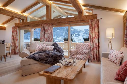 a living room with a couch and a table at Tennerhof Luxury Chalets in Kitzbühel