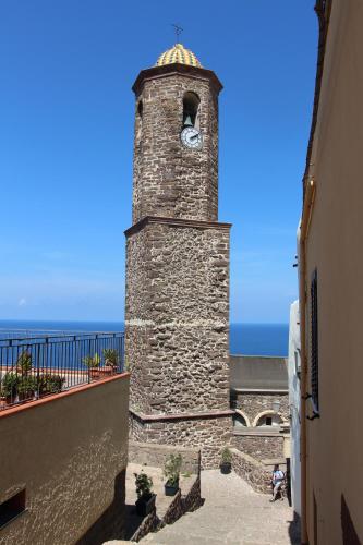 a stone tower with a clock on the side of a building at Il Borgo BagaBaga - Exclusive Country Retreat in Castelsardo