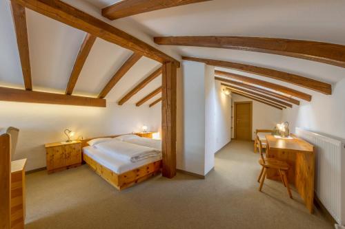 a bedroom with a bed and a desk in a room at Residence Emmy in San Candido