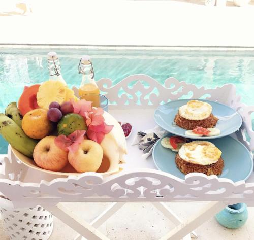a table with two plates of fruit on it at Harmony Villas in Kuta Lombok