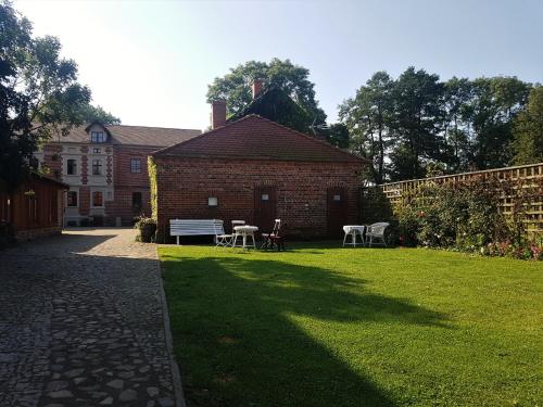 a brick building with a table and chairs in a yard at Leniwka in Świebodzin