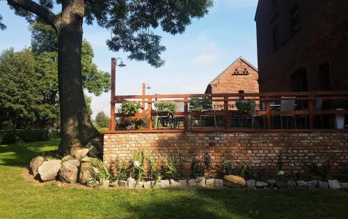a brick retaining wall with a deck in front of a building at Leniwka in Świebodzin