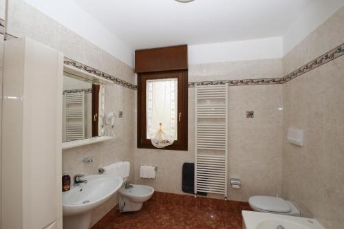 uma casa de banho com um lavatório, WC e um espelho. em Round Venice em Marghera