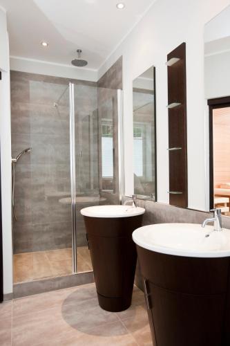a bathroom with two sinks and a shower at Hotel Gräfrather Hof in Solingen