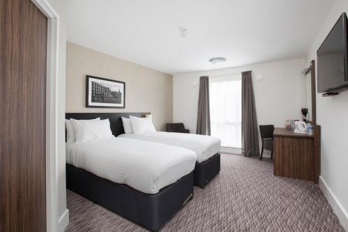 a hotel room with a large bed and a television at Spring River Ebbsfleet by Marston's Inns in Gravesend