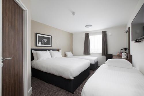 a hotel room with two beds and a window at Spring River Ebbsfleet by Marston's Inns in Gravesend