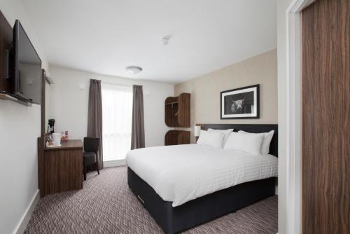 A bed or beds in a room at Spring River Ebbsfleet by Marston's Inns