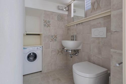 bagno con servizi igienici, lavandino e lavatrice di Villetta Federica by BarbarHouse a Leuca