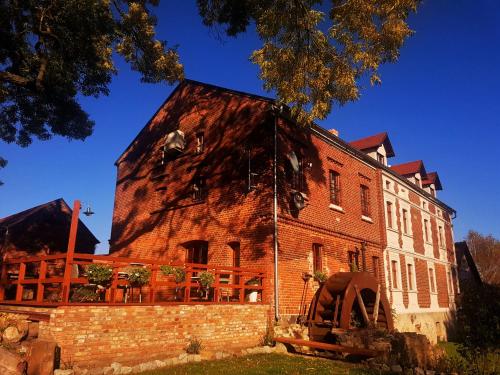 an old red brick building with a rusty roof at Leniwka in Świebodzin