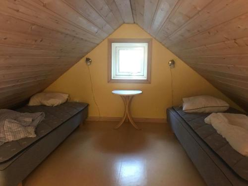 2 camas en una habitación pequeña con ventana en Vilsta Camping and Cottages, en Eskilstuna