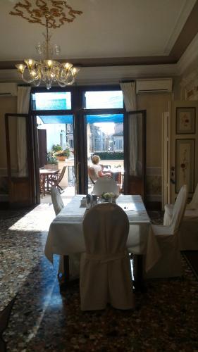 a dining room with a table and chairs and a chandelier at Casa di Carlo Goldoni - Dimora Storica in Chioggia