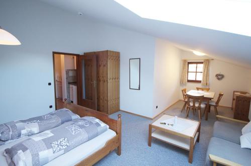 ein Wohnzimmer mit einem Bett und einem Tisch in der Unterkunft Gschwendtnerhof in Aschau im Chiemgau