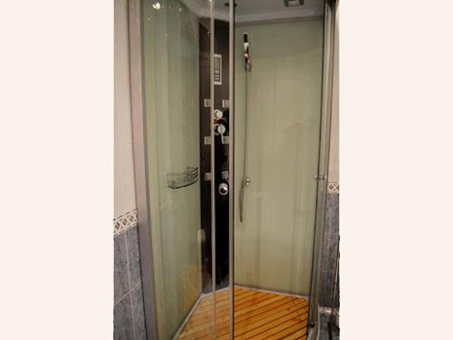 a glass shower in a room with a wooden floor at Atxispe Etxea Casa Rural in Laukiz