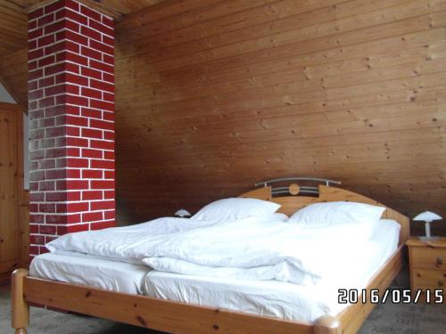 a bed in a room with a wooden ceiling at Ferienhaus Amarell in Breitenbach