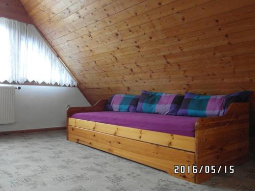Łóżko w pokoju z drewnianym sufitem w obiekcie Ferienhaus Amarell w mieście Breitenbach