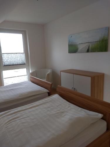 a bedroom with two beds and a window at TiWu - Ferienwohnungen in Steinhude