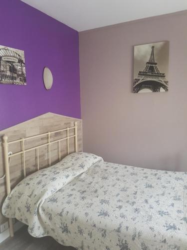 um quarto com uma cama e uma fotografia da Torre Eiffel em Hotel Bernieres em Caen