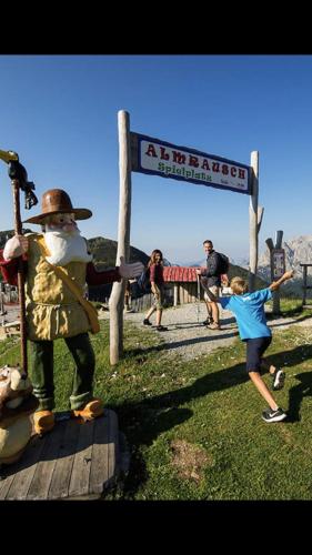 a little girl standing next to a statue of a man at Apartment Sonnleitn/Nassfeld in Sonnenalpe Nassfeld