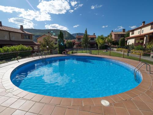 een groot zwembad met blauw water in een tuin bij El Despertar in Boltaña