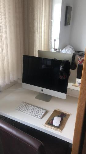 ein Computermonitor, eine Tastatur und eine Maus auf dem Schreibtisch in der Unterkunft Kliemt room in Hilden