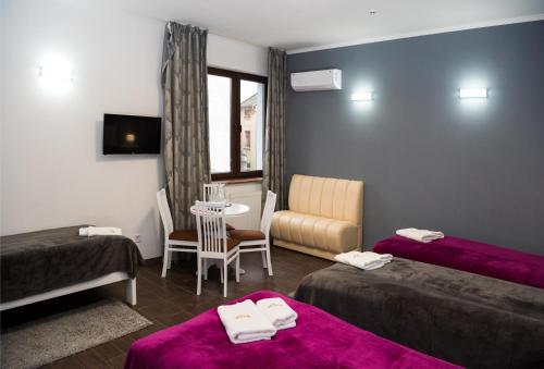 a hotel room with two beds and a table at Hotel " BOUTIQUE " in Uzhhorod